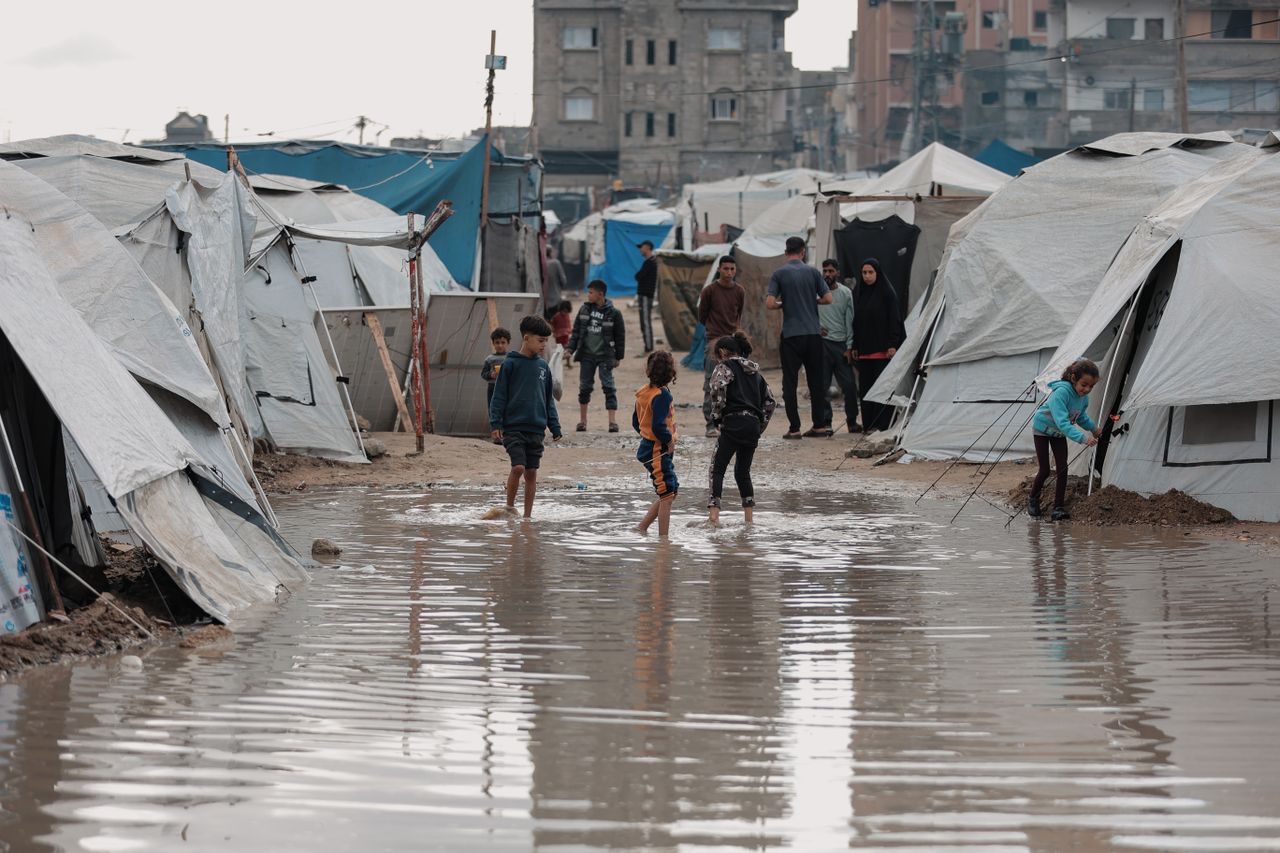 about-01 Children play in a flooded refugee camp in Gaza, reflecting resilience and daily life challenges.