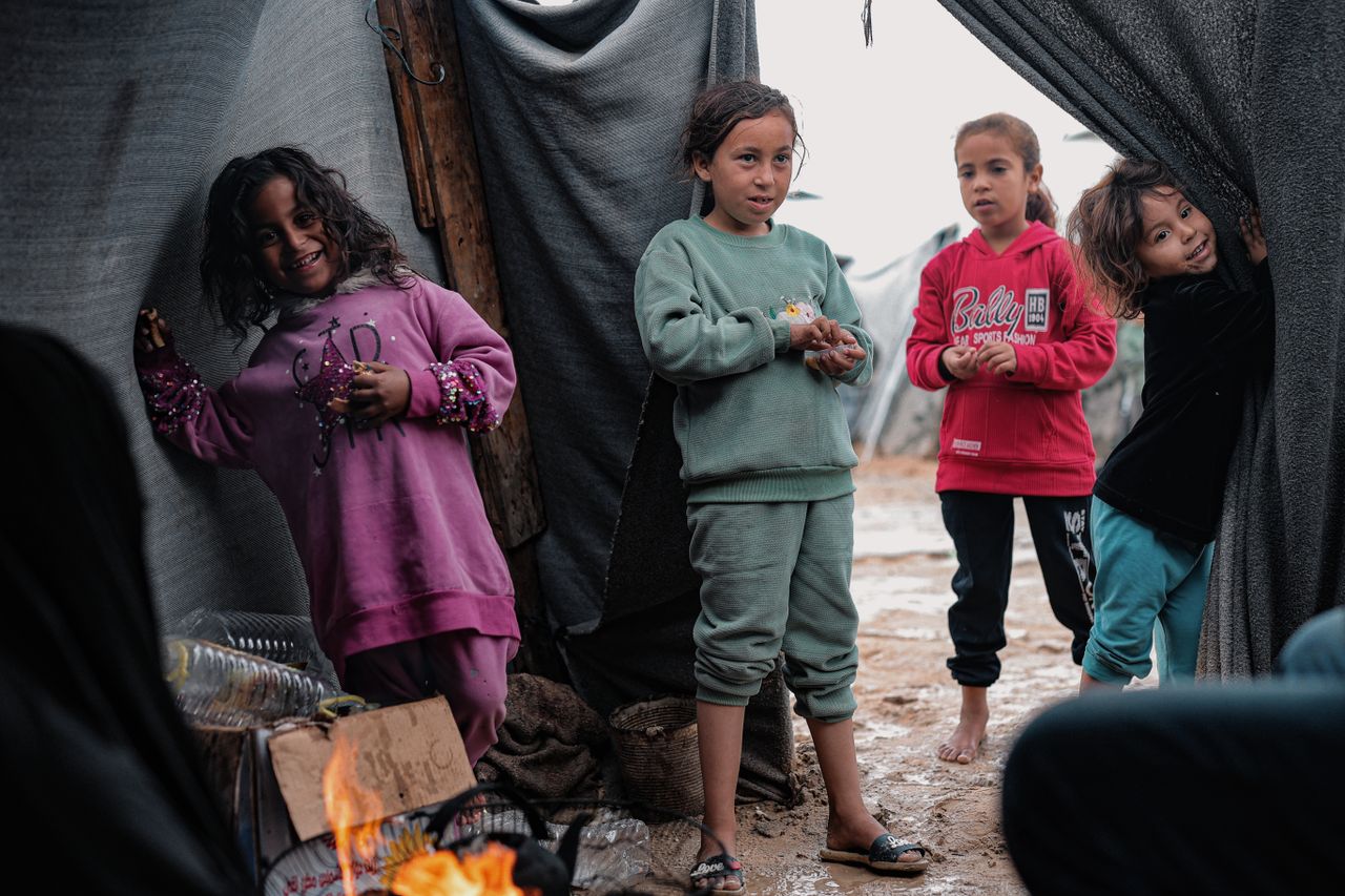 why-choose-us Four children playing near tents in a refugee camp in Gaza, depicting resilience and hope.